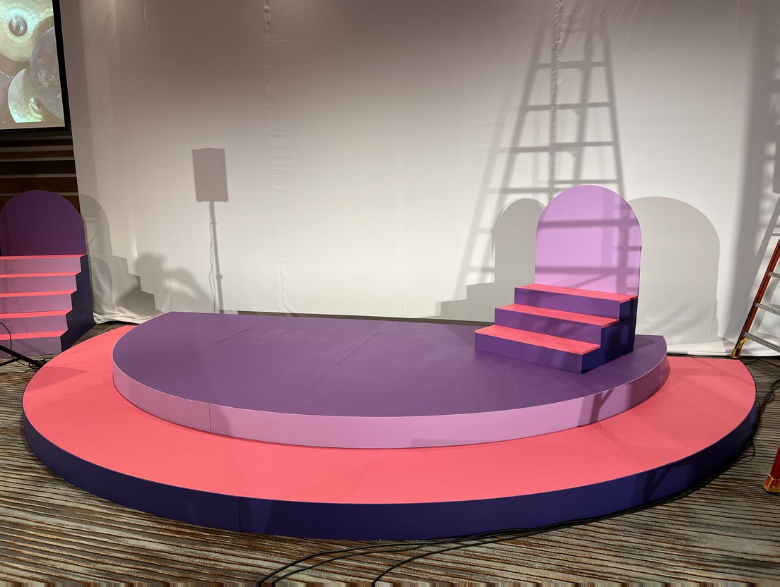 Customized Stages and Fabrication — Pink semicircle stage with matching stair towers — branded presentation set